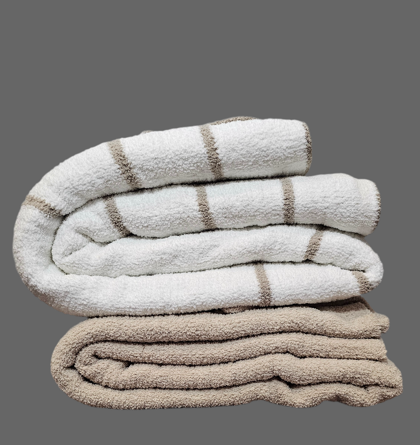 Ultraplush Nest throw blanket in double thickness, draped elegantly over driftwood, showcasing its luxurious softness and durability. Folded on top of classic nest throw to show it's extra thick material and double size