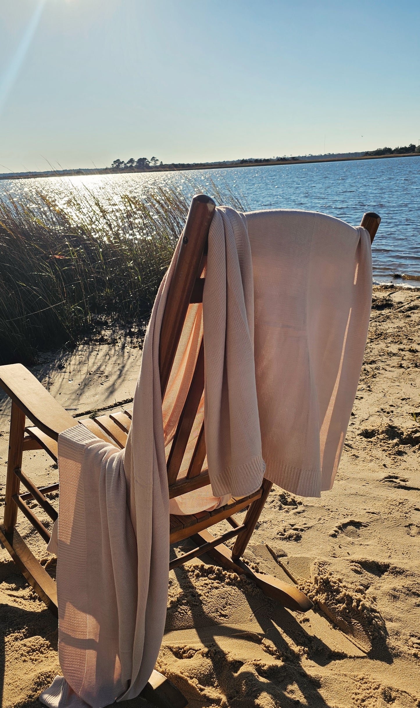 The drift throw in beige almond color, lightweight throw over rocking chair blowing in the beach breeze, oversized throw, travel throw, outdoor throw blanket, easy clean throw, durable bedding