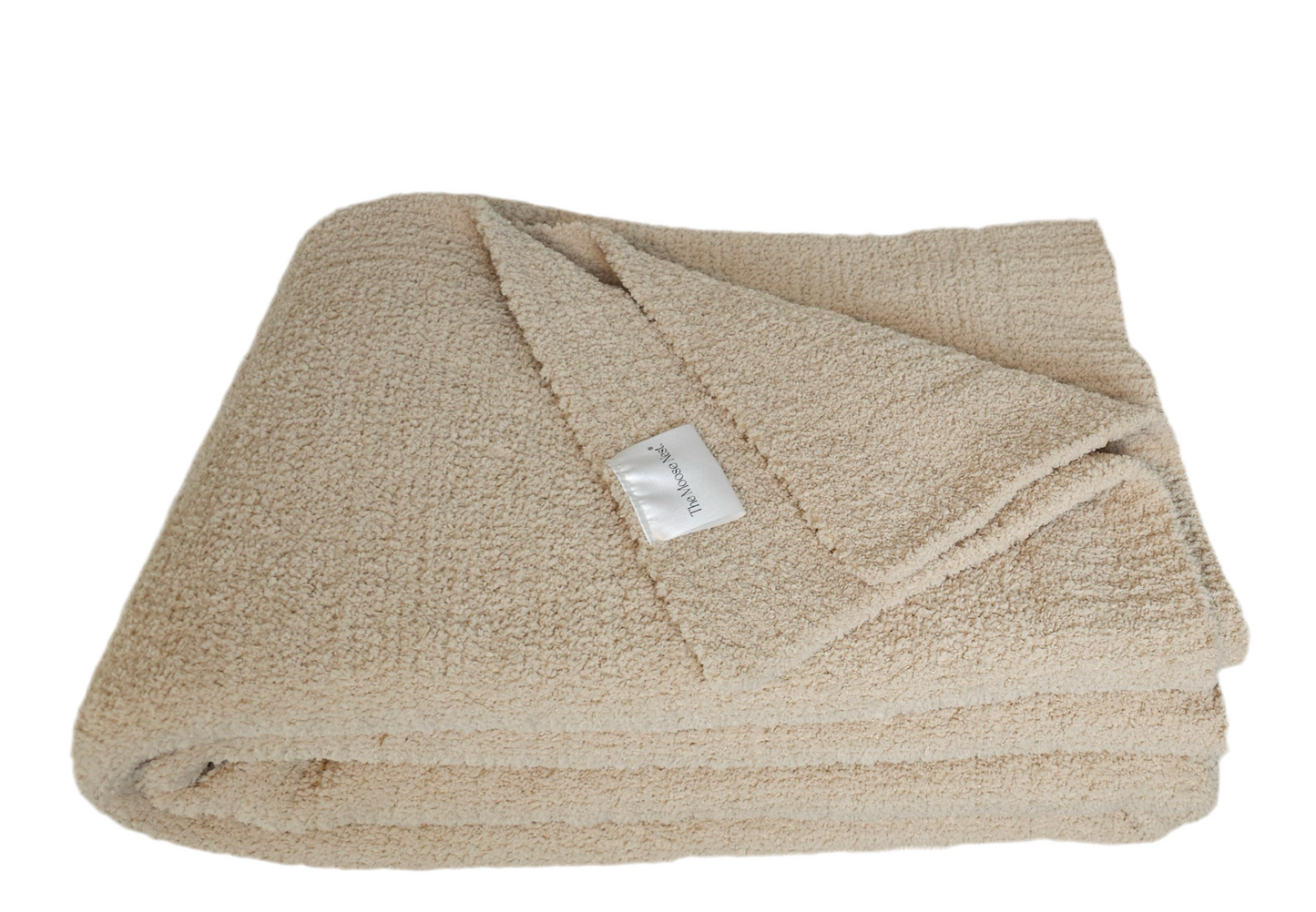 Neutral-toned Sand Nest throw folded to show it's ribbed edge and showing off its ultra-soft plush material and timeless elegance