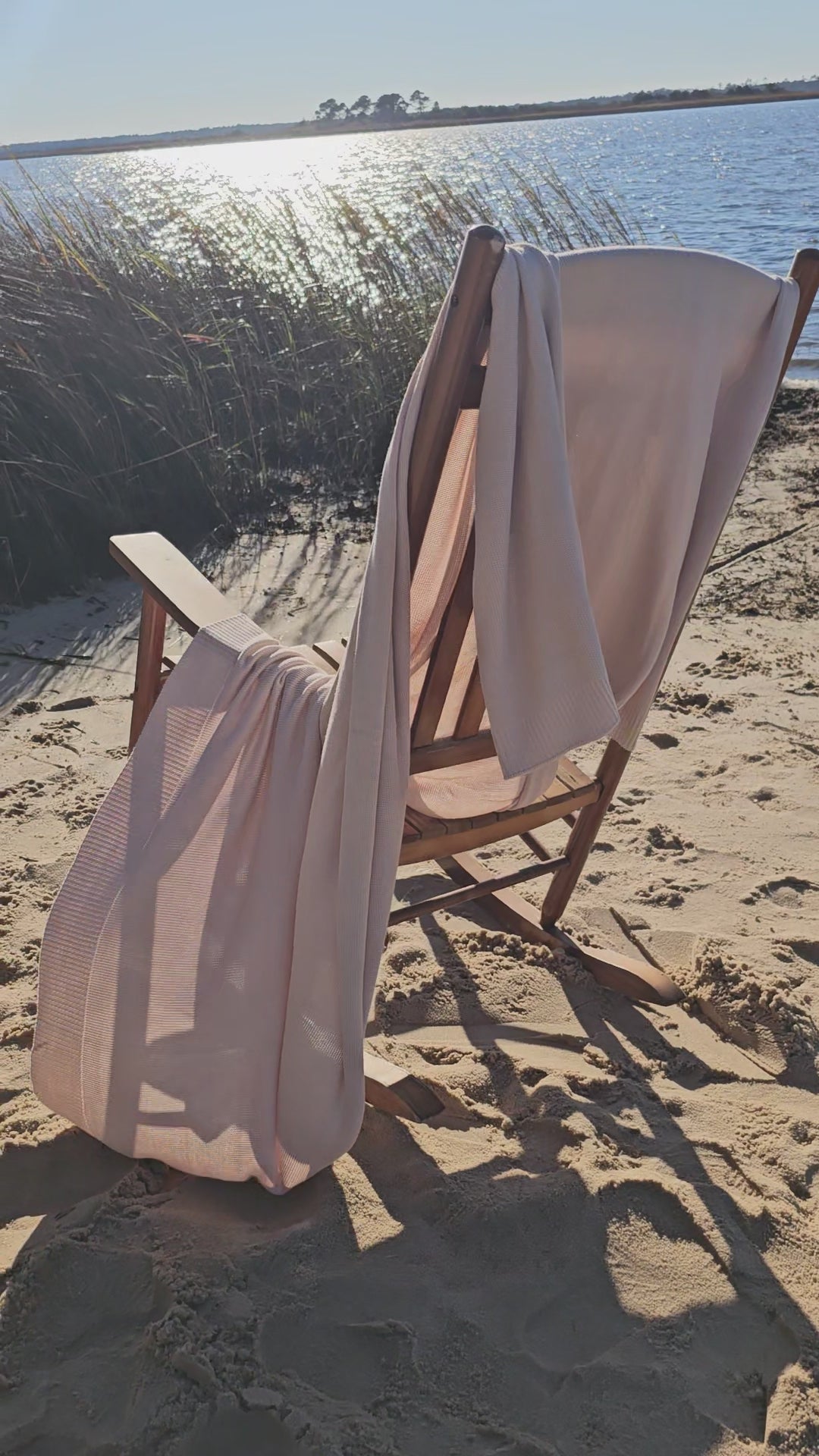 The drift throw in beige almond color, lightweight throw over rocking chair blowing in the beach breeze, oversized throw, travel throw, outdoor throw blanket, easy clean throw, durable bedding