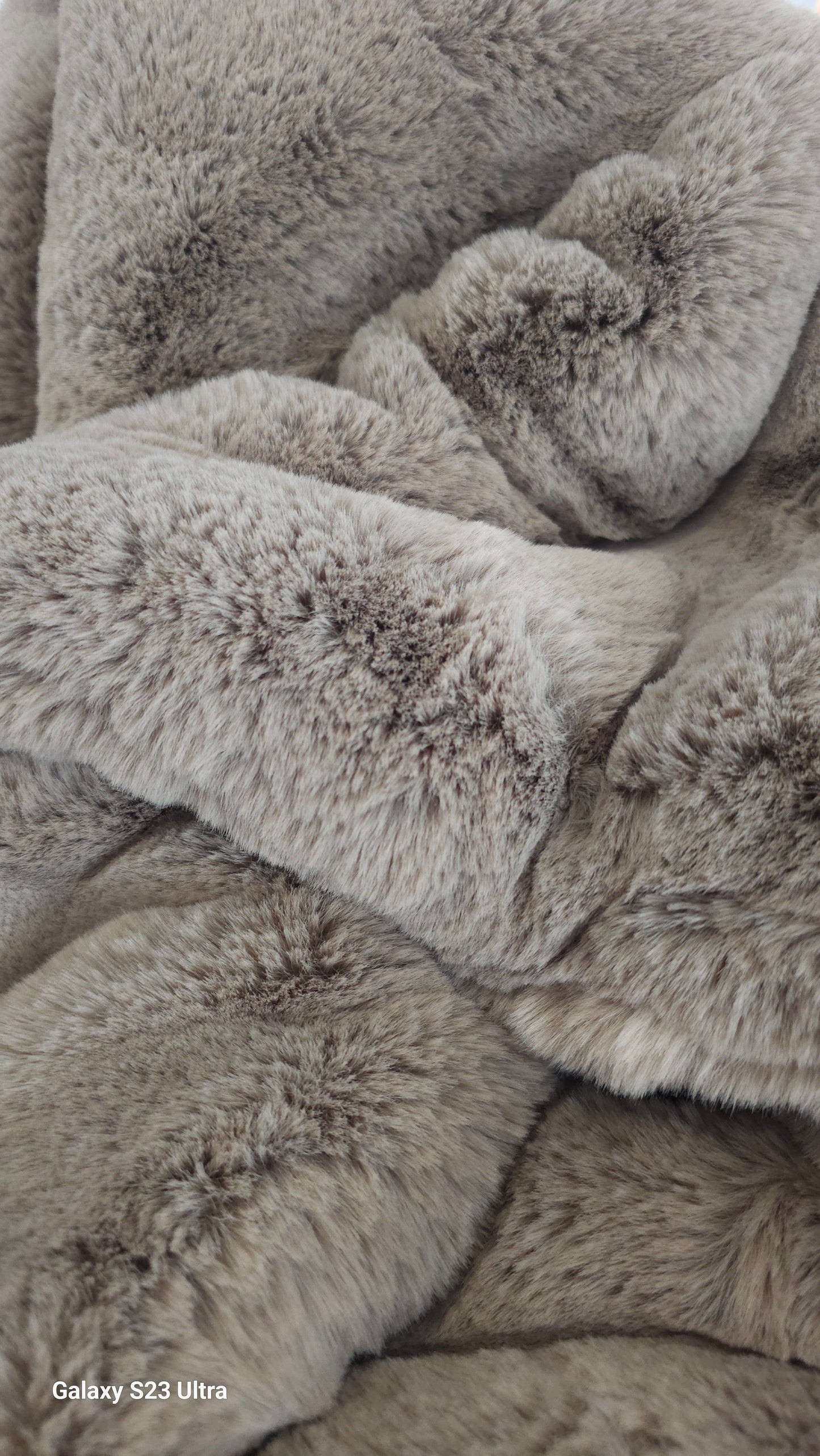 Close up image of a lush grey fur throw blanket