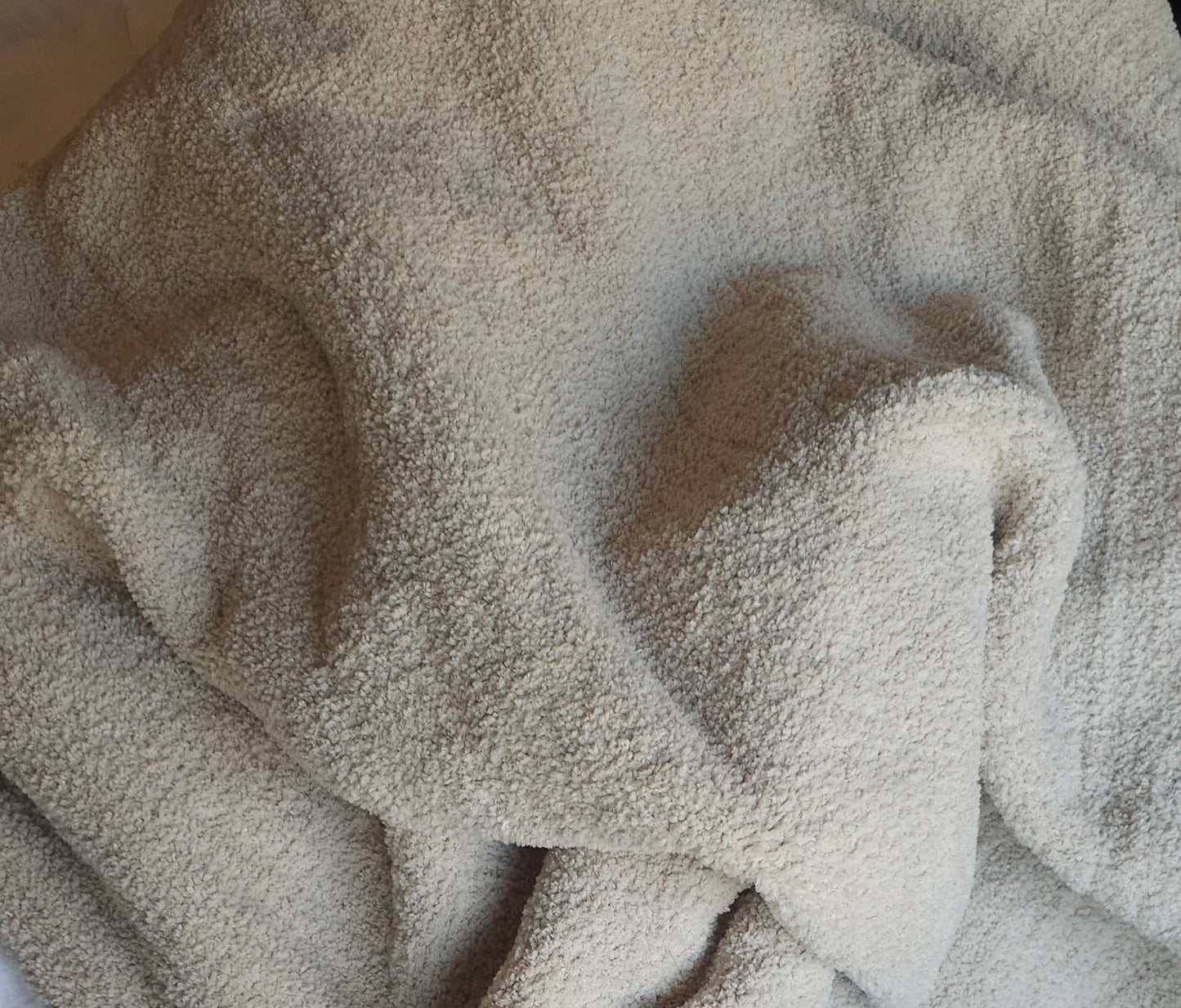 Close up ofNeutral-toned Sand Nest throw, showing off its ultra-soft material and timeless elegance